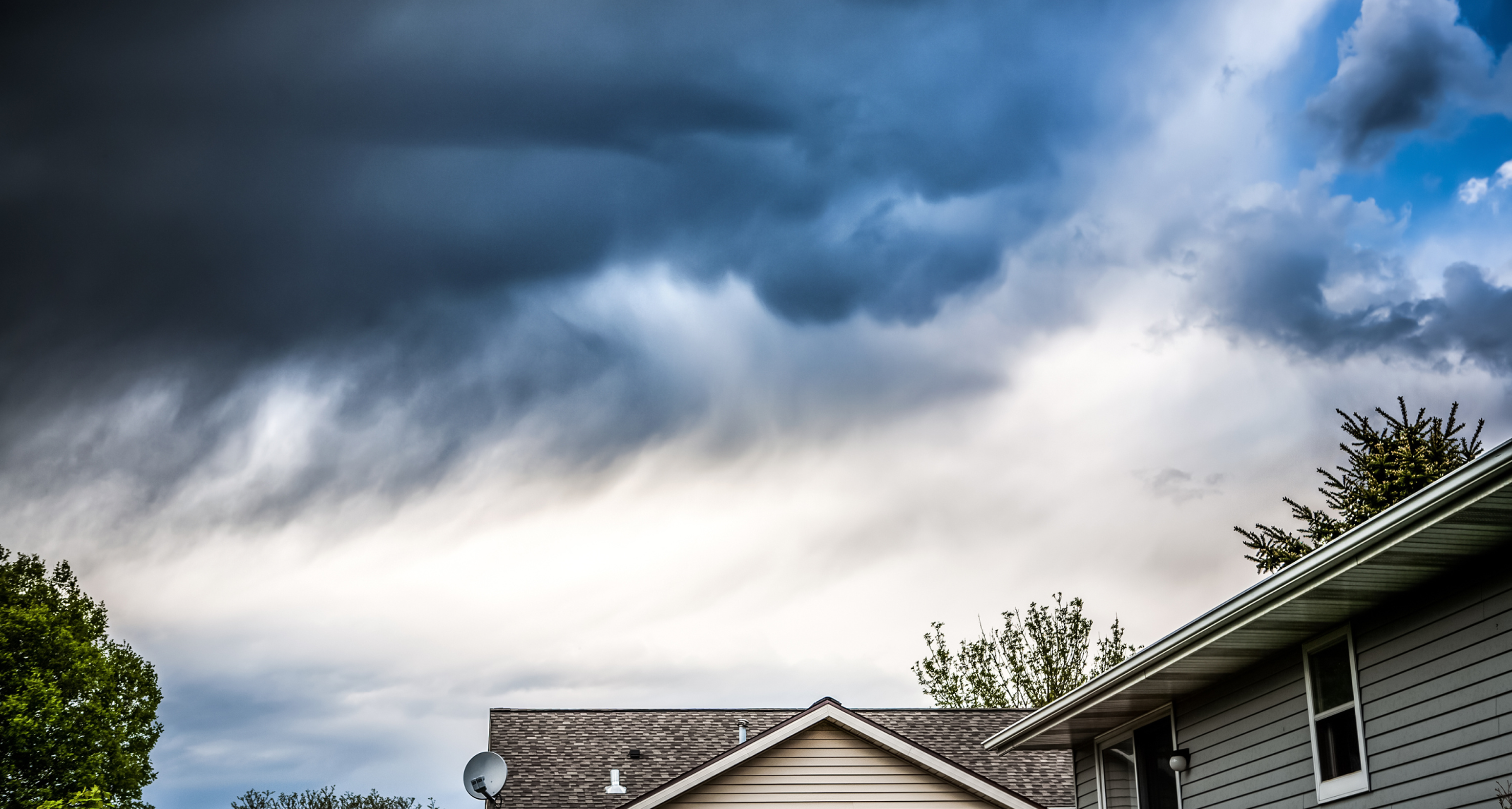 Clouds of a hurricane are forming above a home's ridge line